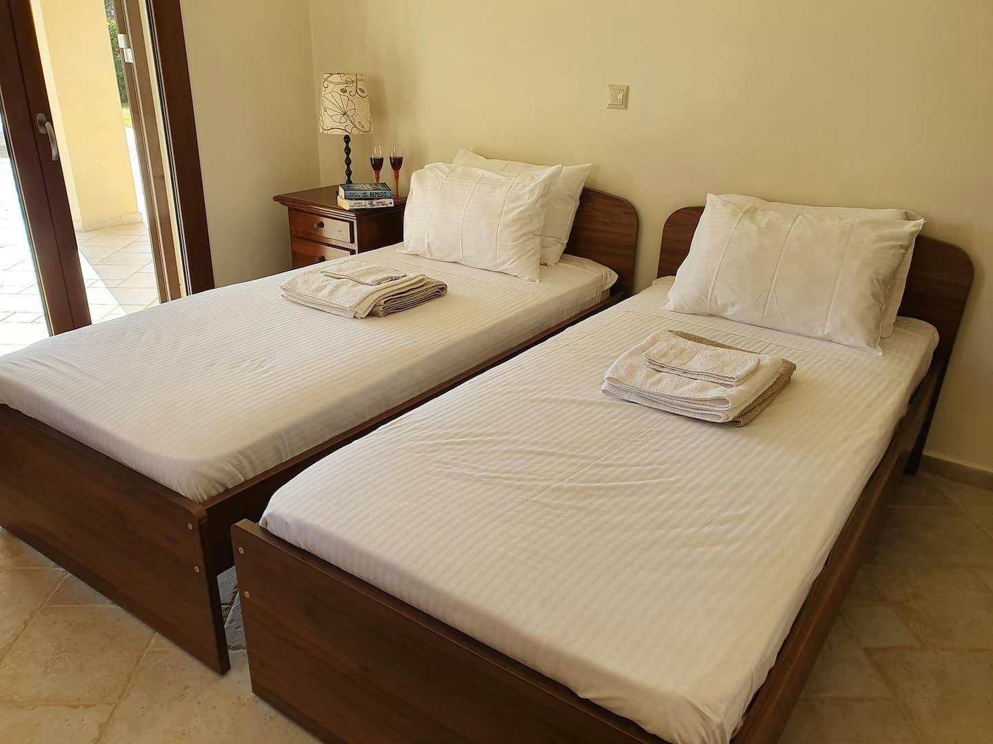 The first bedroom with two single beds and direct access to the pool